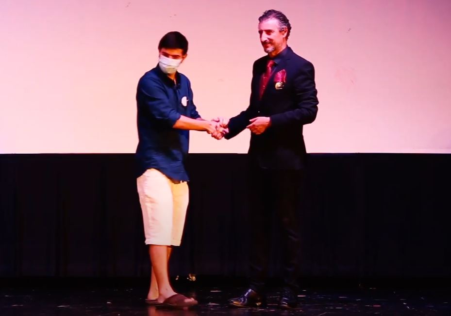 El presentador Antonio Di Mateo y un ganador Cartel del cortometraje "más allá de la sangre"